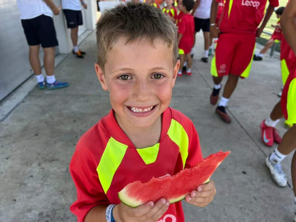 Alumno posa sonriente con su almuerzo saludable en el Campus de Fútbol Lecop impartido en Zaragoza