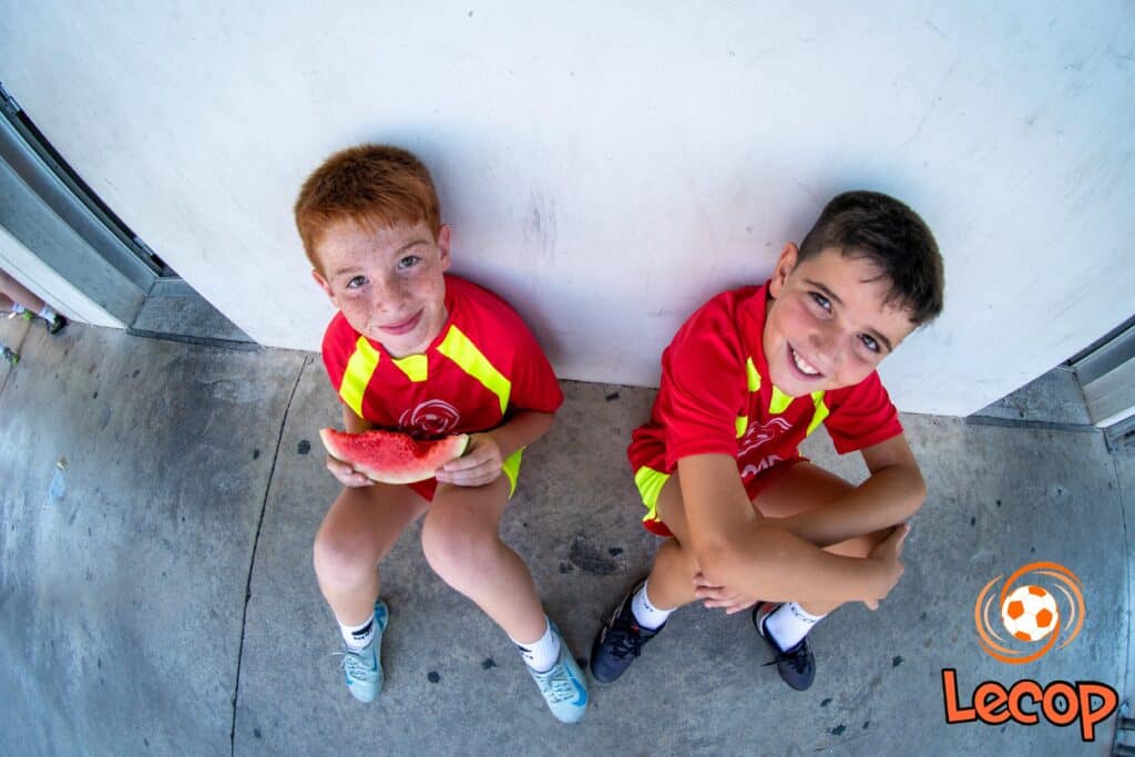 Alumnos descansan a la sombra mientras toman un buen almuerzo sano y saludable que les aporte energía y les ayude a hidratarse en nuestros Campus de Fútbol en Zaragoza